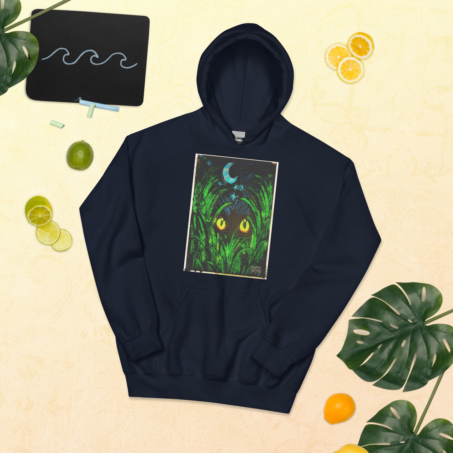 Navy unisex hoodie featuring "Midnight Watcher" artwork – glowing yellow eyes in green grass under a crescent moon (Canva Collection)